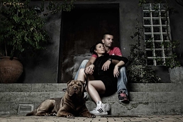 Couple assis sur des marches avec un chien en laisse.
